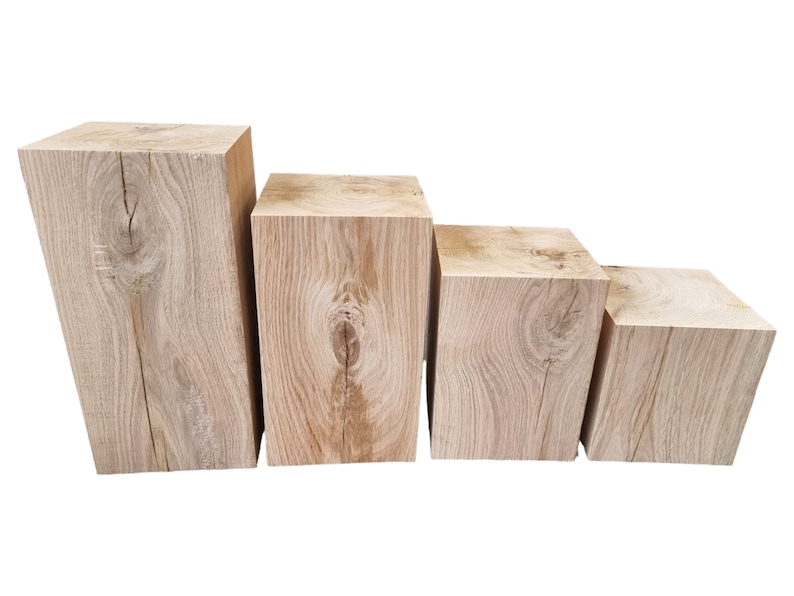 May include: Four wooden blocks of varying sizes, stacked in a staircase formation. The blocks are made of natural wood with a light brown color and a visible grain pattern.