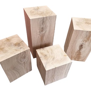May include: Three wooden blocks of varying sizes, each with a natural wood grain finish. The blocks are arranged in a staggered formation, with the largest block in the back and the smallest block in the front.