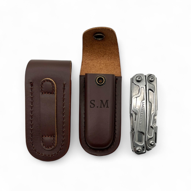 May include: Three items are displayed: two brown leather sheaths and a silver multi-tool. One sheath is closed, the other is open with the initials "S.M" embossed. The multi-tool is next to the open sheath.
