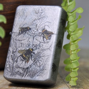 Flip Top Lighter in a case with bees and flowers motive.