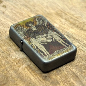 Encendedor con tapa abatible en estuche con carta del tarot: Los enamorados.