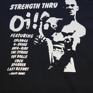 以下が含まれることがあります： 白のグラフィックが施された黒いTシャツ。グラフィックは、戦闘ポーズをとった人物。グラフィックの上に「Strength Thru Oi!」の文字。その下に「Featuring」の文字があり、その後にバンド名がリストアップされている。「Splodge」「4-Skins」「Infa-Riot」「The Strike」「Toy Dolls」「Cock Sparrer」「Last Resort」「Many More」。