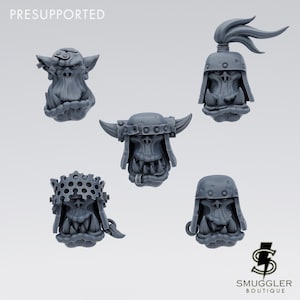 Pode incluir: Cinco cabeças de orc em miniatura de resina cinza com vários capacetes, incluindo capacetes com chifres, um coque e uma viseira perfurada. O texto PRESUPPORTED aparece no canto superior esquerdo e o logotipo SMUGGLER BOUTIQUE no canto inferior direito.