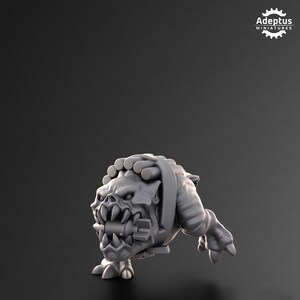 Puede incluir: Una figura en miniatura gris de una criatura monstruosa con dientes afilados y una expresi&oacute;n amenazante. La figura tiene un arn&eacute;s y est&aacute; posada sobre un fondo oscuro. El texto "Adeptus Miniatures" est&aacute; en la esquina superior derecha.