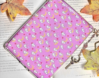 May include: A pink phone case with a repeating pattern of white bunnies, yellow crescent moons, and white stars. The case is in a clear plastic frame.