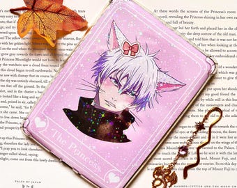 May include: A pink and white phone case with a holographic glitter effect. The case features a cartoon illustration of a white cat with purple hair and a pink bow. The text "The Princess" is written in a pink and white font on the case.