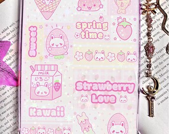 May include: A clear phone case with a pink and white design featuring kawaii illustrations of bunnies, strawberries, and ice cream. Text includes "Spring Time", "Strawberry Love", "Kawaii", and "Milk".