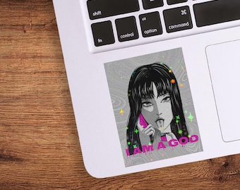 May include: A sticker featuring a black and white illustration of a woman with long hair, holding a pink phone to her ear and sticking out her tongue. The text "I AM A GOD" is printed in pink.