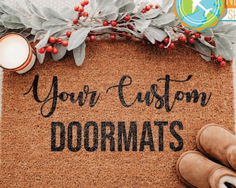 May include: A brown coir doormat with the text "Your Custom Doormats" in black lettering. The doormat is surrounded by greenery and red berries.