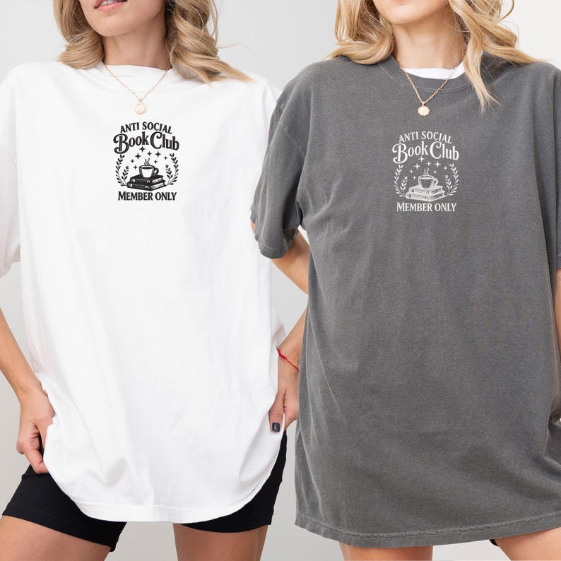 May include: Two oversized t-shirts, one white and one gray, featuring the text "ANTI SOCIAL Book Club MEMBER ONLY" in a circular design with books, a coffee cup, and stars. The shirts have short sleeves and a relaxed fit.