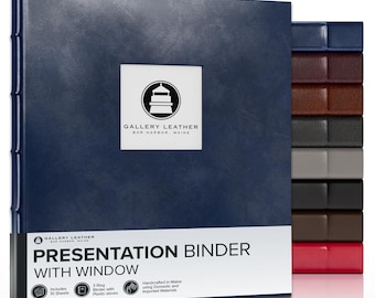 May include: A navy blue three-ring presentation binder with a square window on the front cover. The cover features a logo with a lighthouse and the text GALLERY LEATHER BAR HARBOR, MAINE. A stack of binders in various colors is visible to the right.