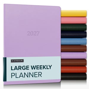 May include: A lavender 2027 large weekly planner with a light blue band featuring the text HARBOR LARGE WEEKLY PLANNER. A stack of additional planners in yellow, pink, dark green, navy, light blue, brown, lavender, brown, orange, and black is visible.