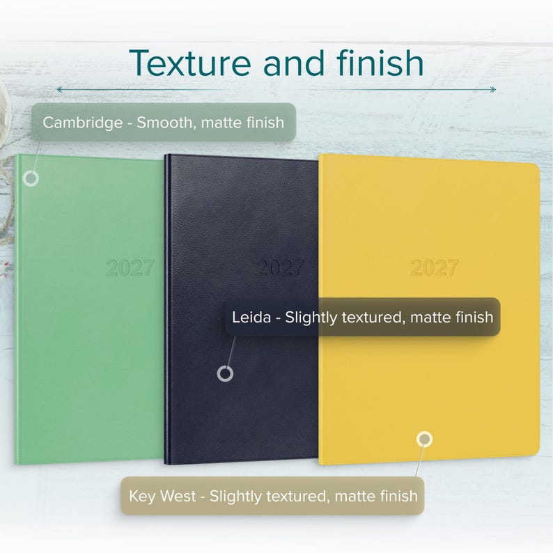 May include: Three rectangular planners labeled 2027 in light green, dark blue, and yellow. The light green Cambridge planner has a smooth matte finish. The dark blue Leida planner and the yellow Key West planner both feature a slightly textured matte finish.