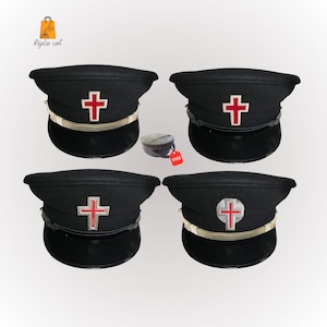 May include: Four black hats with a red cross emblem. The hats have a shiny black brim, a silver band, and a red cross in the centre. A small, round, black case with a red "FREE" tag is also visible.