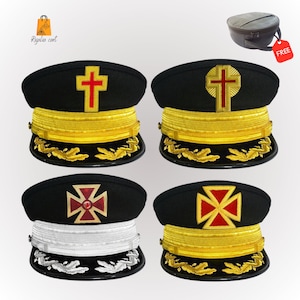 May include: Four black military-style hats with gold trim and different red and gold embroidered crosses. The hats have a white band on the bottom of the hat.