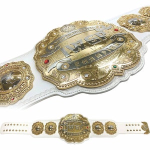 May include: A white leather wrestling championship belt with gold accents and a large central plate featuring the text "IWEP CHAMPION". The belt has multiple smaller plates with a globe design.