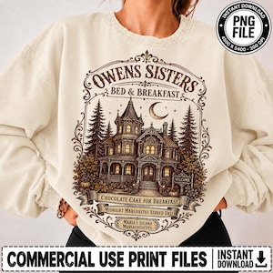Puede incluir: Una sudadera color crema de cuello redondo con un gráfico marrón oscuro de una casa victoriana etiquetada como Owens Sisters Bed & Breakfast. El diseño incluye una luna creciente, pinos y el texto Chocolate Cake for Breakfast.
