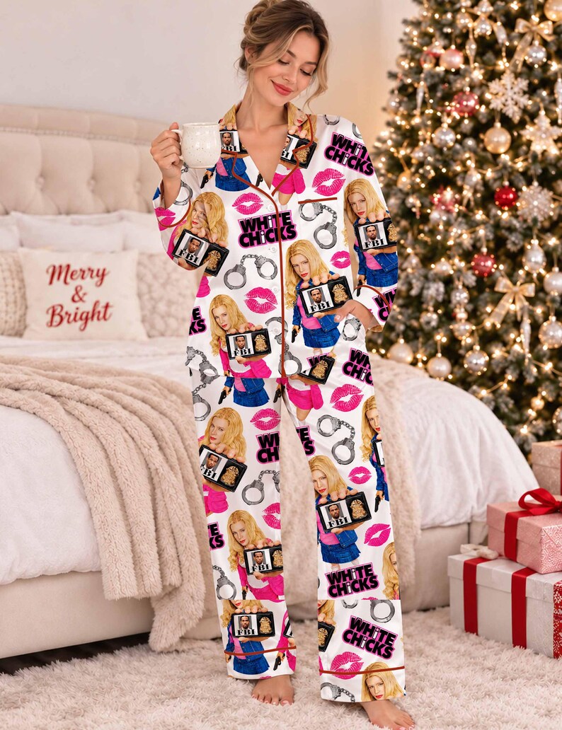 May include: A white long-sleeve button-down pajama set featuring a repeating print of the movie title White Chicks, FBI badges, handcuffs, and pink lips. The pajamas have a notched collar and brown piping along the edges of the shirt and pants.