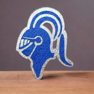 May include: A blue and silver glitter knight helmet cutout. The helmet has a plume on top and a face shield.
