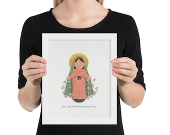 May include: A framed illustration of Our Lady of Guadalupe, a religious figure, depicted in a blue and green robe with a pink dress underneath. The image is surrounded by flowers and the text "Our Lady of Guadalupe pray for us" is at the bottom.