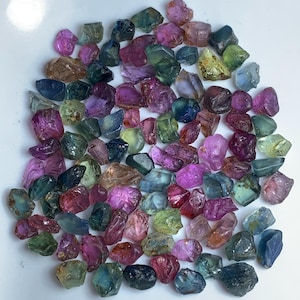 Peut inclure: Une collection de pierres précieuses multicolores facettées en vrac. Les pierres précieuses sont un mélange de bleus, de verts, de roses et de jaunes. Les pierres précieuses sont toutes taillées grossièrement et ont un aspect naturel et non poli.