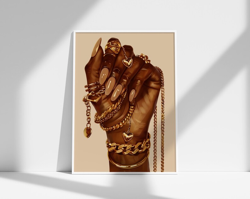 Pode incluir: Uma impress&atilde;o emoldurada com uma m&atilde;o adornada com joias de ouro. A m&atilde;o, com unhas longas e polidas, &eacute; coberta com v&aacute;rias correntes de ouro, pulseiras e an&eacute;is. A obra de arte tem um fundo quente e neutro, e as joias incluem pingentes em forma de cora&ccedil;&atilde;o.