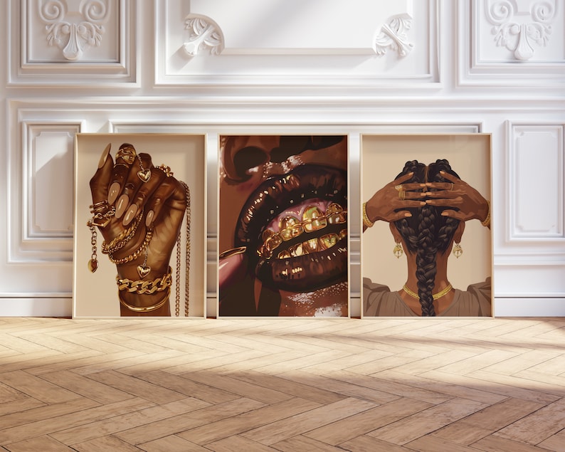 Pode incluir: Tr&ecirc;s impress&otilde;es de arte emolduradas com ilustra&ccedil;&otilde;es de mulheres negras. Uma mostra uma m&atilde;o adornada com joias de ouro, outra mostra l&aacute;bios com dentes de ouro e a terceira retrata cabelo tran&ccedil;ado com acess&oacute;rios dourados.