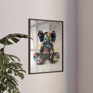 May include: A framed print of a black and white graffiti-style illustration of a cartoon character with a black background and colourful accents.