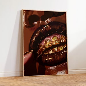 Pode incluir: Uma impress&atilde;o de arte emoldurada com um close-up de uma boca com l&aacute;bios castanhos escuros e brilhantes e grelhas de dentes douradas. A obra de arte tem uma paleta de cores quentes com tons de castanho e dourado.