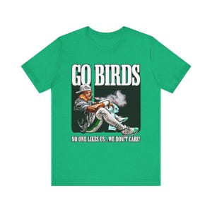 May include: Green t-shirt with the text "GO BIRDS" above an illustration of a baseball player smoking a pipe. The text "NO ONE LIKES US...WE DON'T CARE!" is below the illustration.