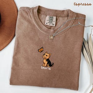 Folded ESPRESSO Comfort Colors shirt with cute Yorkshire Terrier puppy and butterfly graphic, personalized dog lover tee with custom pet name, minimalist pet shirt flat lay aesthetic gift idea.