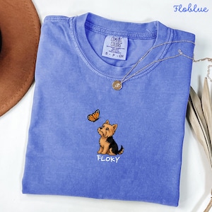 Folded FLO BLUE   Comfort Colors shirt with cute Yorkshire Terrier puppy and butterfly graphic, personalized dog lover tee with custom pet name, minimalist pet shirt flat lay aesthetic gift idea.