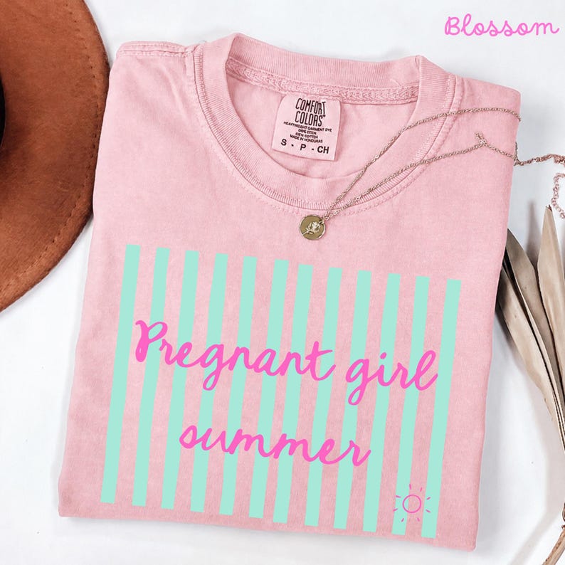 Blossom Comfort Colors shirt with vertical mint green stripes and pink script text reading “Pregnant girl summer” centered across the front, with a small pink sun icon detail at the bottom corner.