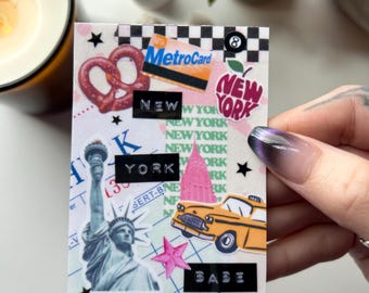 May include: A collage featuring New York City imagery. Includes a pretzel, MetroCard, Statue of Liberty, a yellow taxi, and the text "NEW YORK" and "BABE". Accented with stars and a pink starburst.
