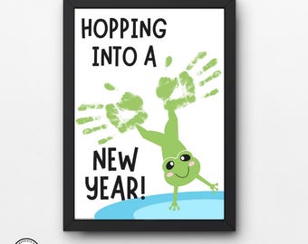 May include: A green frog with handprint arms is hopping into a new year. The text "Hopping into a New Year!" is written in black on a white background.