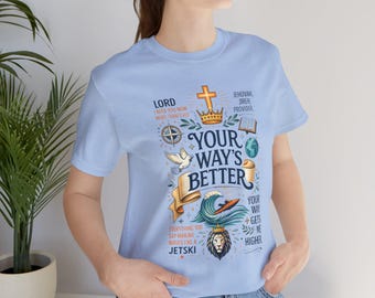May include: Light blue t-shirt with a graphic design featuring the text "YOUR WAY'S BETTER" and other religious phrases and symbols. The design includes a cross, crown, dove, and lion.
