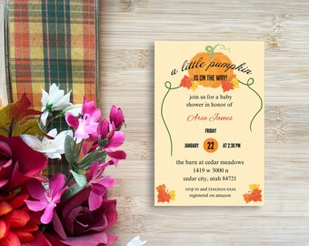 Puede incluir: Una invitación a una fiesta de bienvenida al bebé con temática de calabaza. La invitación está decorada con hojas de otoño y el texto "a little pumpkin is on the way!" La invitación es para Aria James y está programada para el viernes 22 de enero a las 2:30 PM en el granero de Cedar Meadows, 1419 W 3000 N, Cedar City, Utah 84721. RSVP a (xxx)XXX-XXXX. Registrado en Amazon.