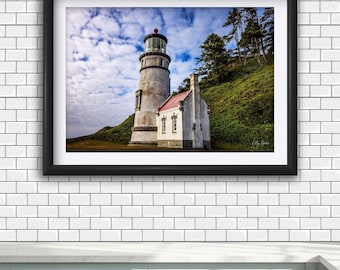 Pode incluir: Uma impressão artística emoldurada apresentando um farol branco cilíndrico alto com um telhado vermelho na lanterna, ligado a um pequeno edifício branco com telhado vermelho, num monte relvado com árvores sob um céu azul com nuvens.