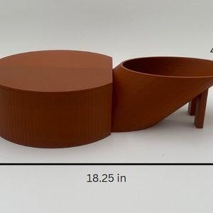 May include: A terracotta-colored ceramic planter with a cylindrical base and a curved, angled spout. The planter measures 4 inches tall and 18.25 inches wide. The spout is 4.5 inches tall.