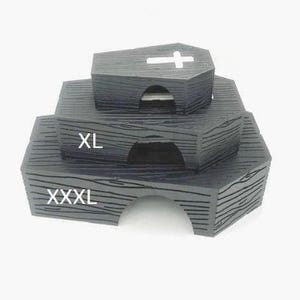 May include: A set of three black coffin-shaped nesting boxes with white text labels. The largest box is labeled "XXXL", the middle box is labeled "XL", and the smallest box is labeled with a white cross.