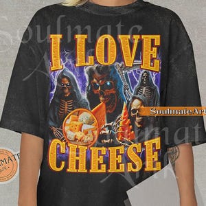 May include: Black t-shirt with a graphic design featuring skeletal figures and the text "I LOVE CHEESE" in gold lettering. The design includes images of cheese and lightning bolts.