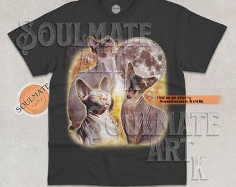 以下が含まれることがあります： 三匹のスフィンクス猫と満月が描かれたダークグレーのTシャツ。「SOULMATE ART」と「Find us on etsy - SoulmateArtK」の文字が入っています。