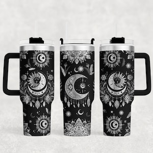 Può includere: Tre bicchieri in acciaio inossidabile con coperchi e manici neri. Ogni bicchiere presenta un design argento e nero di lune, stelle e sole con un motivo a mandala.