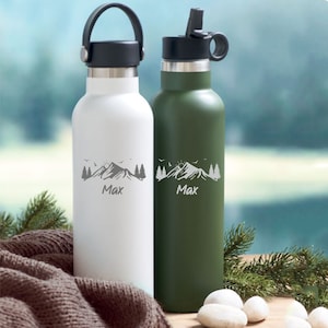 Könnte beinhalten: Zwei Edelstahl-Wasserflaschen mit einem Berg- und Sonnenmotiv und dem Namen Max auf jeder. Die Flasche links ist weiß und die Flasche rechts ist grün.