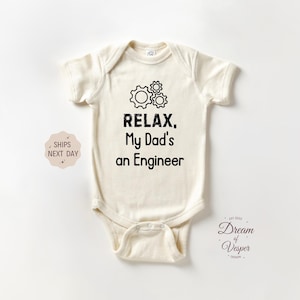 May include: Cream-colored baby bodysuit with the text "RELAX, My Dad's an Engineer" in black, along with a gear graphic. The bodysuit is short-sleeved and has a snap closure at the bottom. The design is centered on the front.