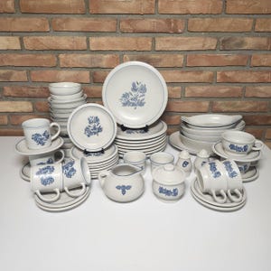May include: A complete set of blue and white floral patterned dinnerware, including plates, bowls, cups, saucers, a creamer, a sugar bowl, and salt and pepper shakers.