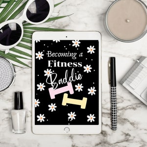 Puede incluir: Una tableta blanca con una pantalla negra que muestra el texto "Becoming a Fitness Baddie" con un gr&aacute;fico de mancuerna rosa y amarilla y margaritas blancas sobre un fondo negro.