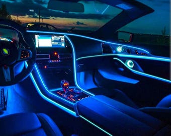 May include: The interior of a car with blue LED lights installed around the dashboard and door panels. The lights create a futuristic and modern look.