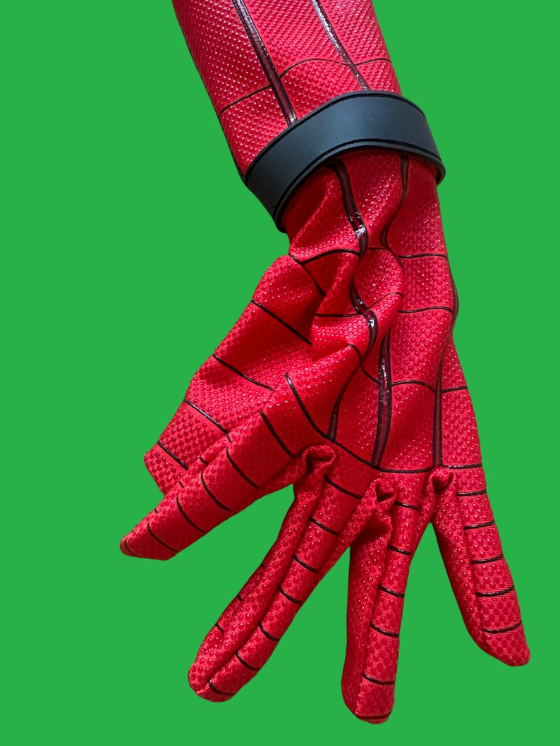 May include: Red and black Spiderman glove with a black wrist strap. The glove has a webbed design.