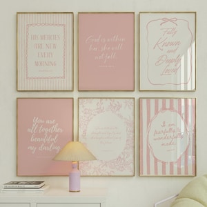 May include: Six framed wall art prints featuring pink and white color schemes with inspirational text, displayed above a table lamp. The prints include phrases like His Mercies Are New Every Morning, God is within her, and I am fearfully & wonderfully made.